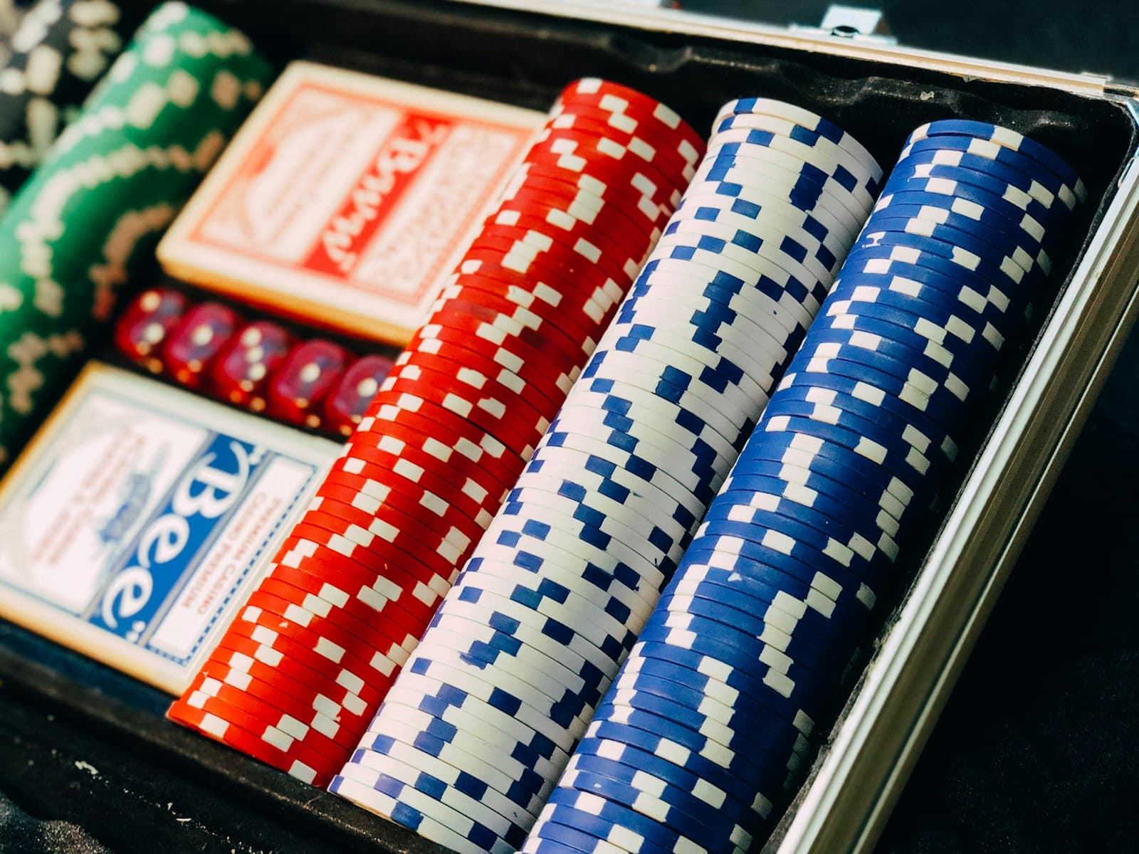 Poker chip set with stacked chips, playing cards, and dice in a case
