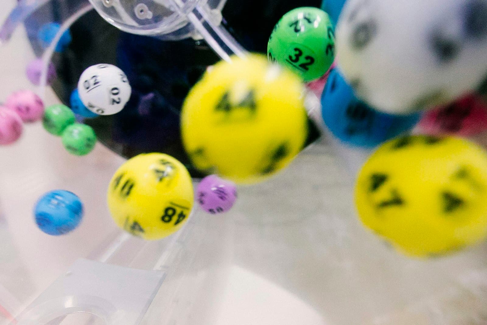 Numbered lottery balls tumbling inside a draw machine
