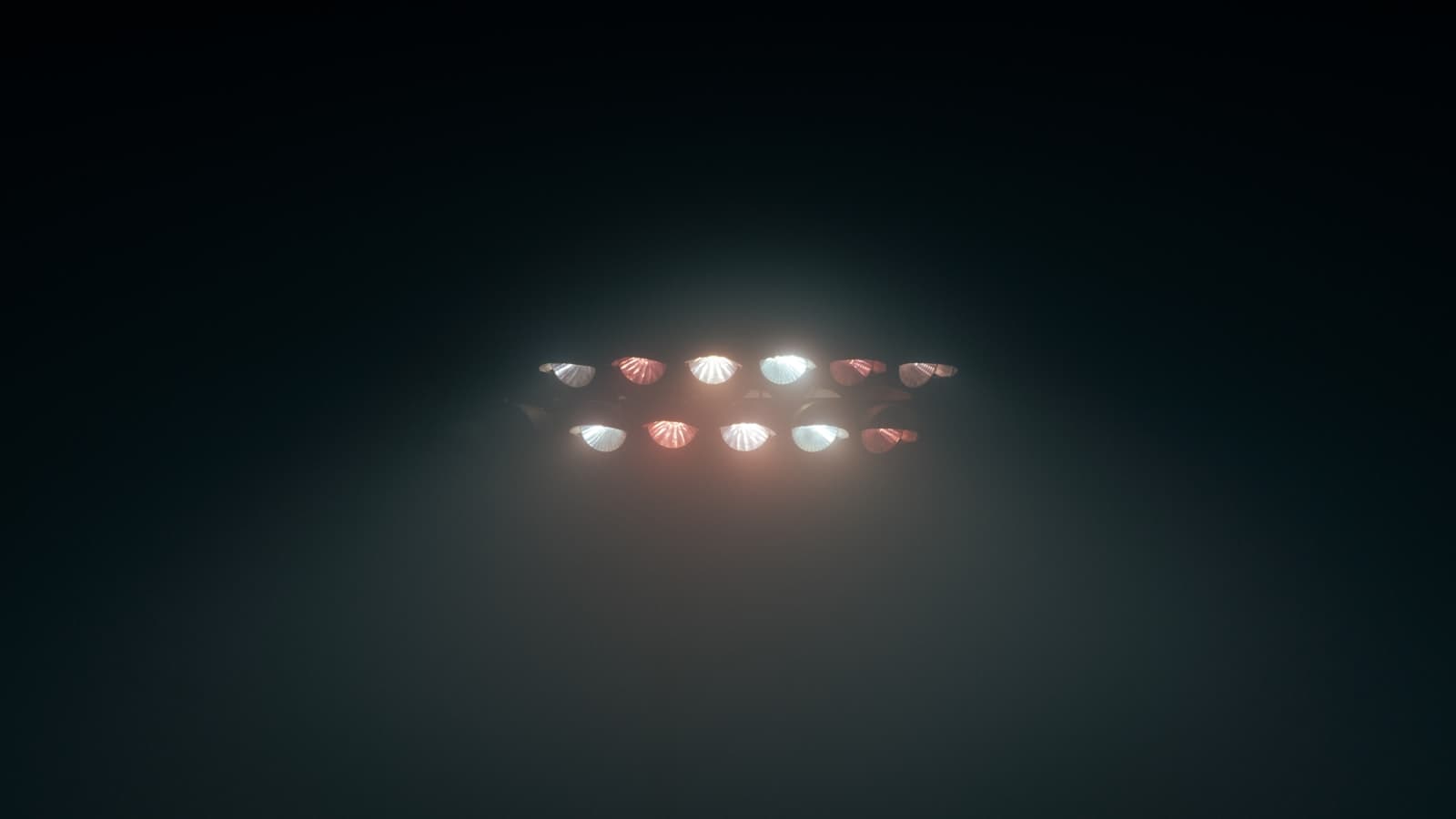 Stadium floodlights glowing through fog in the dark