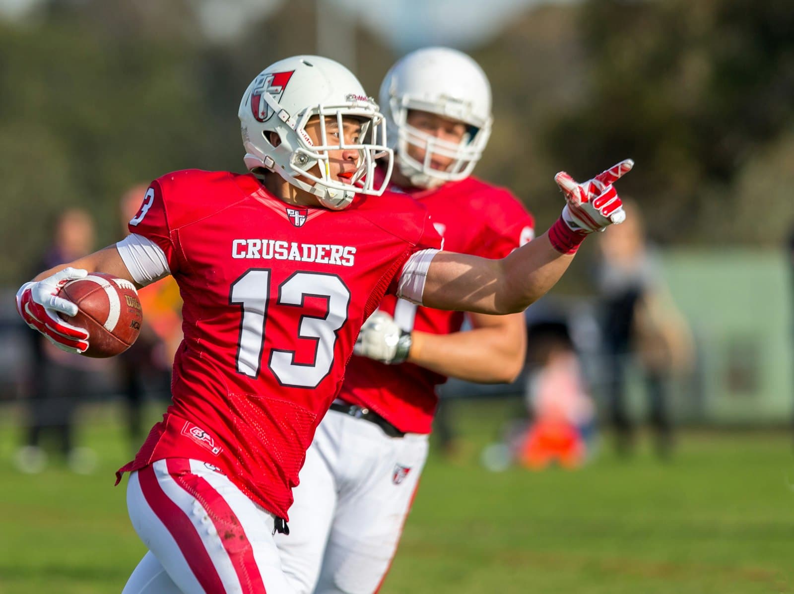 Amateur football ball carrier breaking a tackle during a game