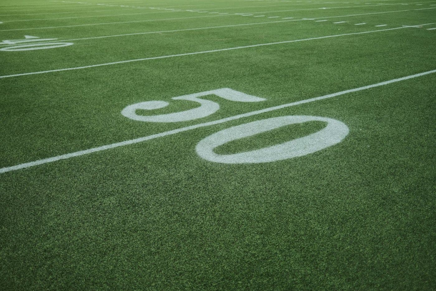Painted 50-yard line number on a green football field