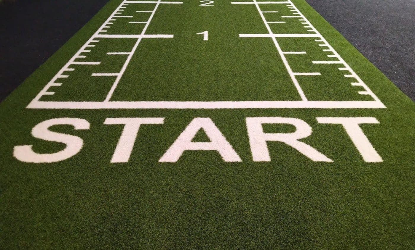 Green turf runway with a painted START line and yard markers